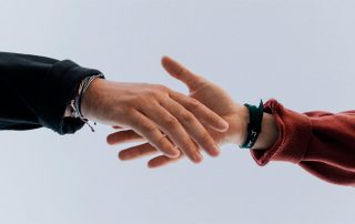 Two people reaching to hold hands